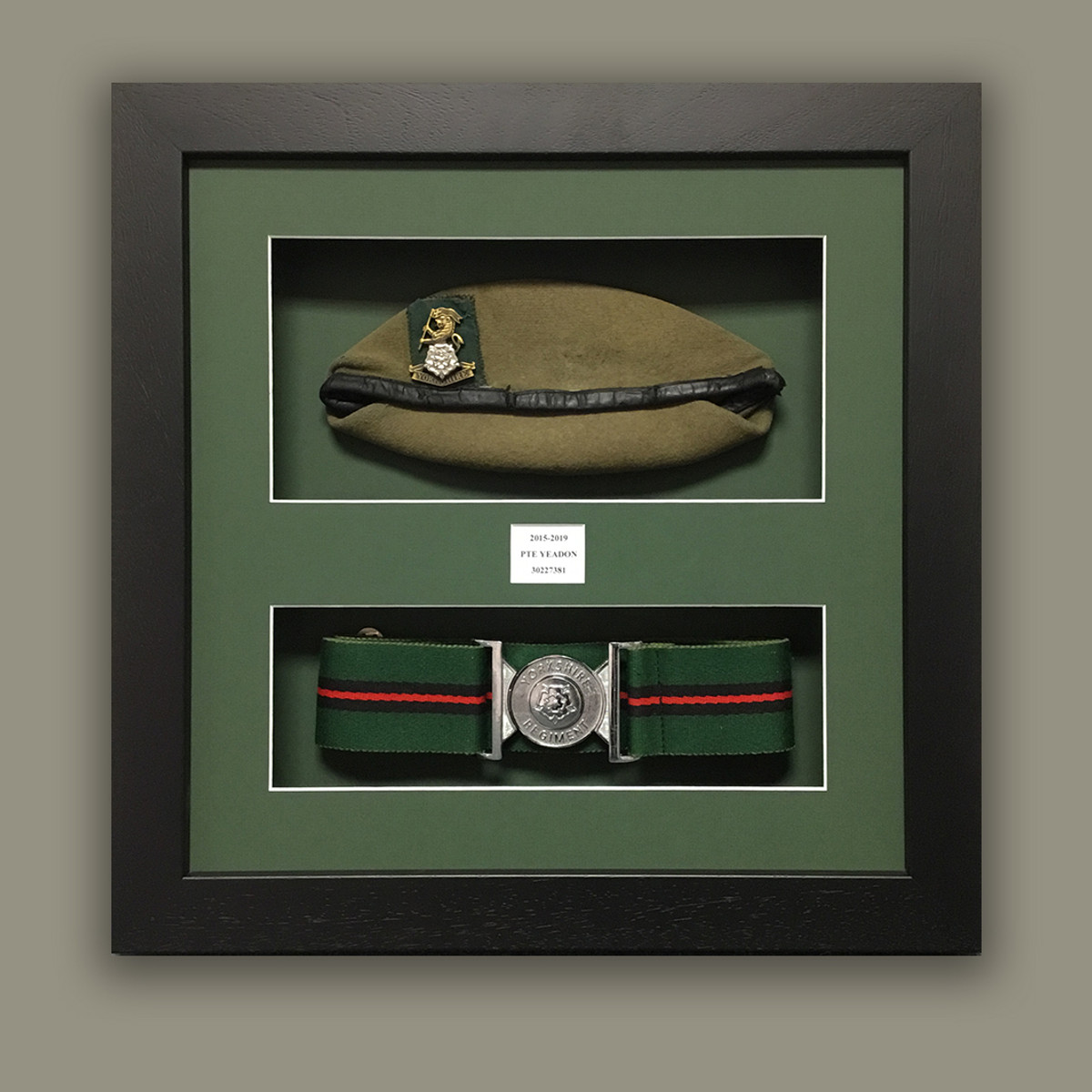 A green beret and stable belt, double aperture on a green conservation mount.