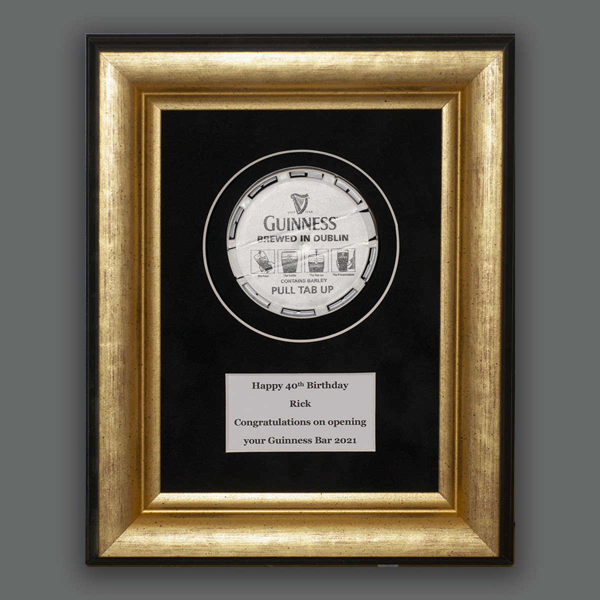 A collectable float-mounted on black velvet in a black and gold ornate frame.
